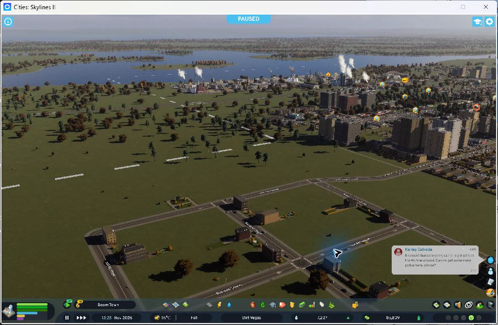 The new campus district at the final pause. The small park sits beside its outer street; existing downtown buildings rise beyond it.