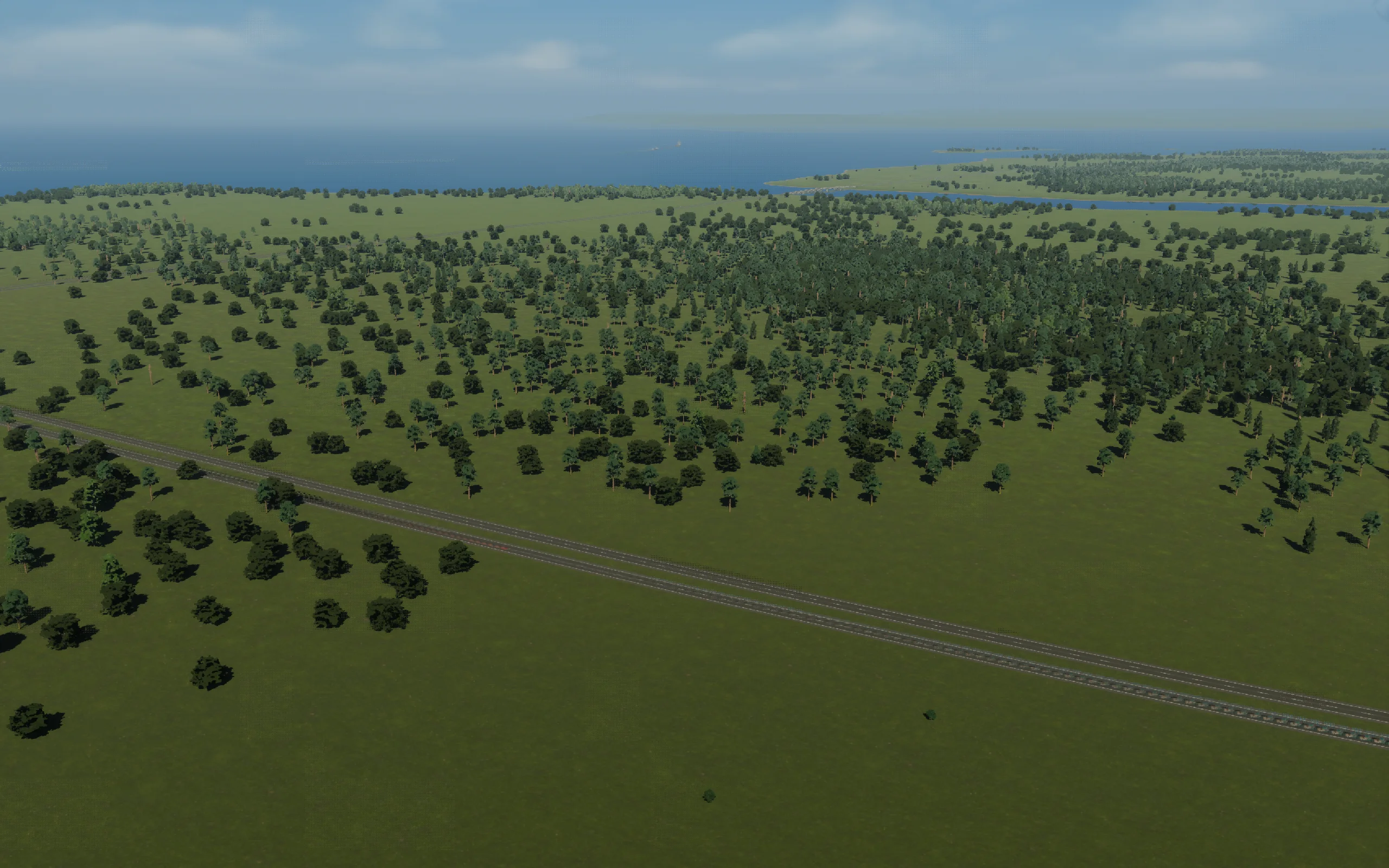The freight site before construction: highway, open ground and forest. The distant district began here.